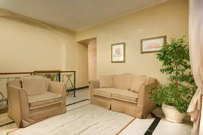 a living room with two chairs and a plant at Hotel Aberdeen in Rome