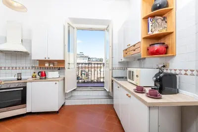 a kitchen with white cabinets and a large window at Monti Deluxe - Terrace Spectacular View in Rome