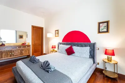 a bedroom with a large bed with a red headboard at BigFamilyRome - Vatican & Navona in Rome
