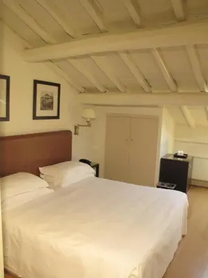 a bedroom with a white bed and a wooden ceiling at Hotel Albergo Santa Chiara in Rome