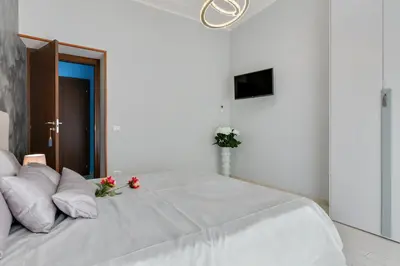a bedroom with a large white bed with flowers on it at Louise at Colosseum in Rome