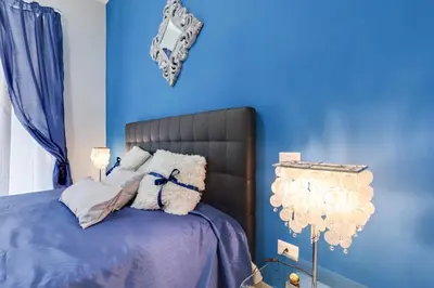 a blue bedroom with a bed with a blue wall at Louise at Colosseum in Rome