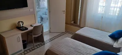 a hotel room with a bed and a desk and a television at Vatican View Rooms in Rome