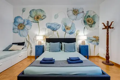 a bedroom with a bed with blue flowers on the wall at BigFamilyRome - Spanish Steps in Rome