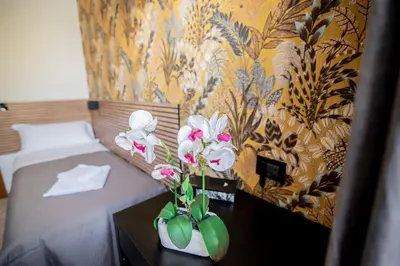 a bedroom with a bed with a vase of flowers on a table at Hotel Dell'Urbe in Rome