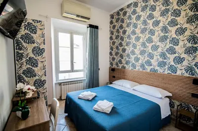 a bedroom with a blue bed with towels on it at Hotel Dell'Urbe in Rome