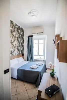 a small bedroom with a bed and a window at Hotel Dell'Urbe in Rome