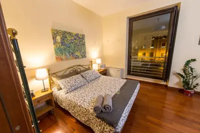 a bedroom with a bed and a large window at BigFamilyRome - Sistine Chapel in Rome