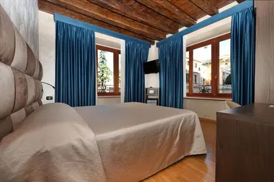 a bedroom with blue curtains and a large bed at Hotel Rimini in Rome
