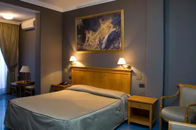 a hotel room with a bed and a painting on the wall at Hotel Rimini in Rome