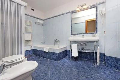 a bathroom with a sink and a tub and a toilet at Hotel Rimini in Rome