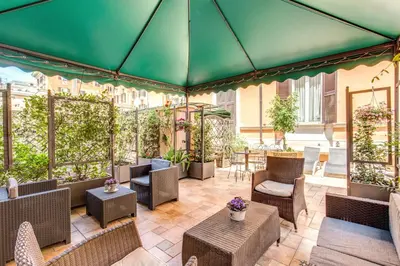 a patio with chairs and tables and a green tent at Roman Terrace in Rome