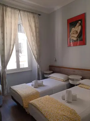 a room with three beds and a window at Hotel Castelfidardo in Rome