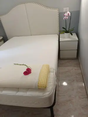 a white bed with a yellow pillow on it at Hotel Castelfidardo in Rome