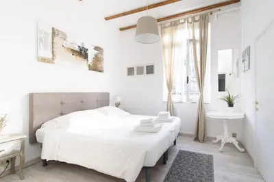 a white bedroom with a white bed and a sink at White terrace apartment navona in Rome