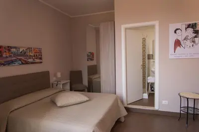a bedroom with a bed and a mirror at La Terrazza di Evelina Guest House in Rome
