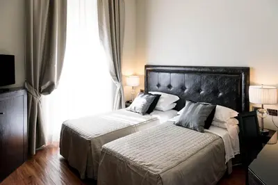 a hotel room with two beds and a window at Le Stanze Di Federica in Rome