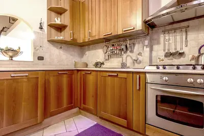 a kitchen with wooden cabinets and a stove at GuestHost - Palazzo Farnese Historical Home in Rome