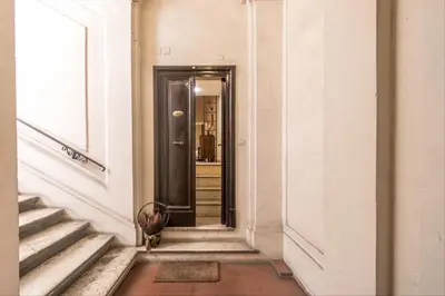 a hallway with a black door in a building at GuestHost - Palazzo Farnese Historical Home in Rome