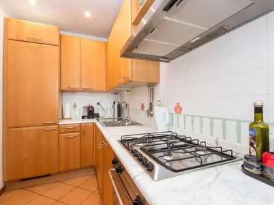 a kitchen with wooden cabinets and a stove top oven at TREVI luxury with terrace in Rome