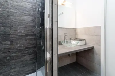 a bathroom with a sink and a glass shower at White Terrace Ostilia in Rome