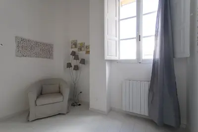 a white room with a chair and a window at White Terrace Ostilia in Rome