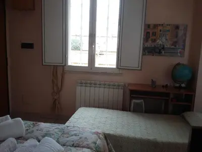 a bedroom with two beds and a desk and a window at Monolocale Monteverde in Rome
