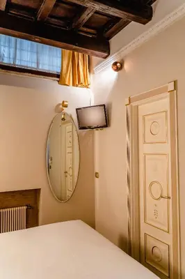 a bedroom with a bed and a mirror and a door at Locanda Del Sole-Roma Piazza Di Spagna Ripetta in Rome