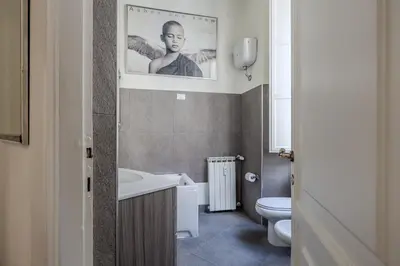 a bathroom with a toilet and a picture of a man at Appartamento Trevi Vicolo Scanderbeg in Rome