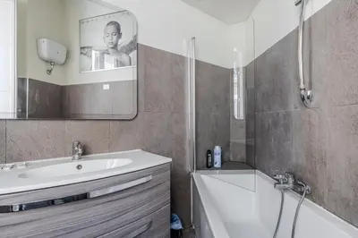 a bathroom with a sink and a tub and a mirror at Appartamento Trevi Vicolo Scanderbeg in Rome
