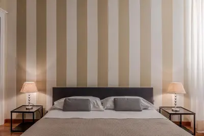a bedroom with a bed and two tables with lamps at Appartamento Trevi Vicolo Scanderbeg in Rome