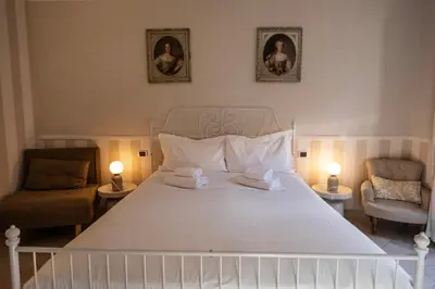 a bedroom with a large white bed and two chairs at Mario's apartament in the Spanish Steps in Rome