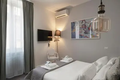 a bedroom with a bed and a chair and a window at Trevi Luxury Terrace in Rome