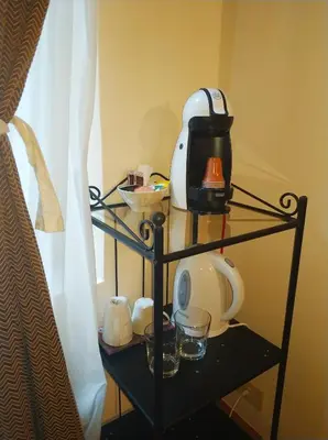 a glass shelf with a tea kettle and glasses on it at Baldassini Suites in Rome