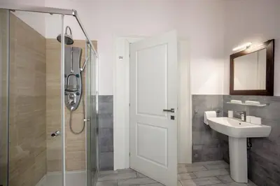 a bathroom with a shower and a sink and a mirror at Baldassini Suites in Rome