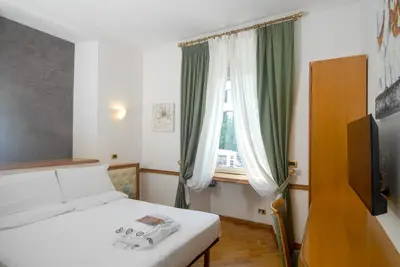 a small bedroom with a bed and a window at Hotel Regina Margherita in Rome