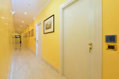a hallway with yellow walls and a white door at Fabio dei Velapazza Guesthouse in Rome