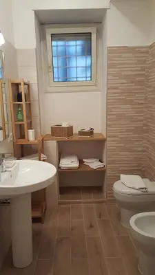 a bathroom with a sink and a toilet and a window at homedieci in Rome
