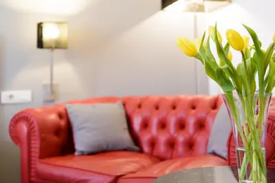 a vase of yellow flowers on a table with a couch at At Home Townhouse - Filiberto in Rome