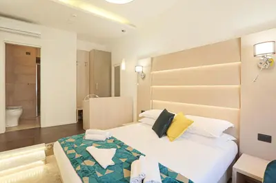 a bedroom with a large bed and a bathroom at DaVinci Relais Guest House in Rome