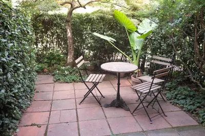a patio with a table and chairs and a tree at Forum Apartment in Rome