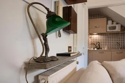 a green lamp sitting on a shelf next to a couch at Forum Apartment in Rome
