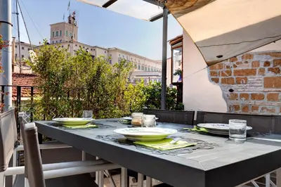 a table with plates and bowls on top of a patio at Casa Modelli in Rome