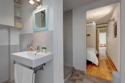a bathroom with a white sink and a bedroom at Casa Modelli in Rome