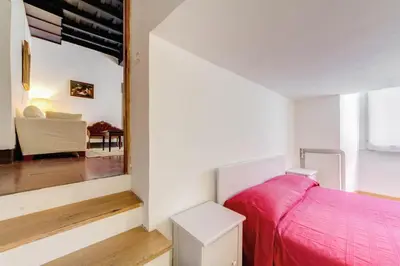 a bedroom with a pink bed and a mirror at Campo dei Fiori Stunning and Quiet in Rome