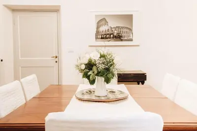 a dining room with a table with a vase of flowers at Suite Rondanini in Rome