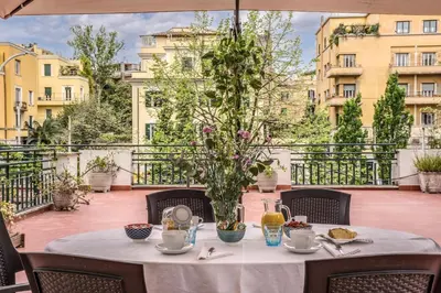 a table with a white table cloth on a balcony at Circus Maximus Home in Rome