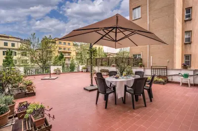 a patio with a table and an umbrella at Circus Maximus Home in Rome