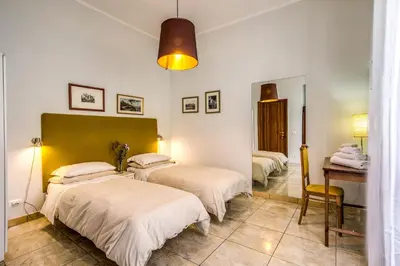 a room with three beds and a table and a desk at Circus Maximus Home in Rome