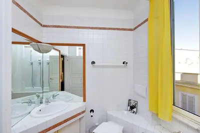 a bathroom with a tub and a sink and a mirror at Trastevere Lovely Studio Apartment in Rome